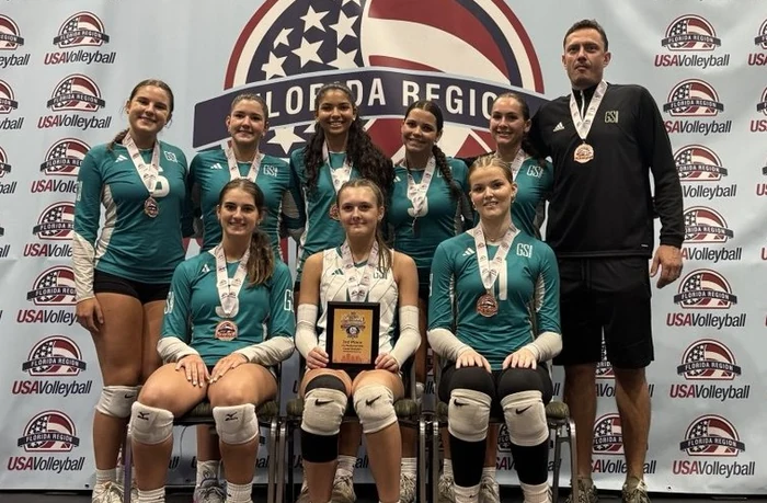 GSI volleyball athletes holding medals and a team award