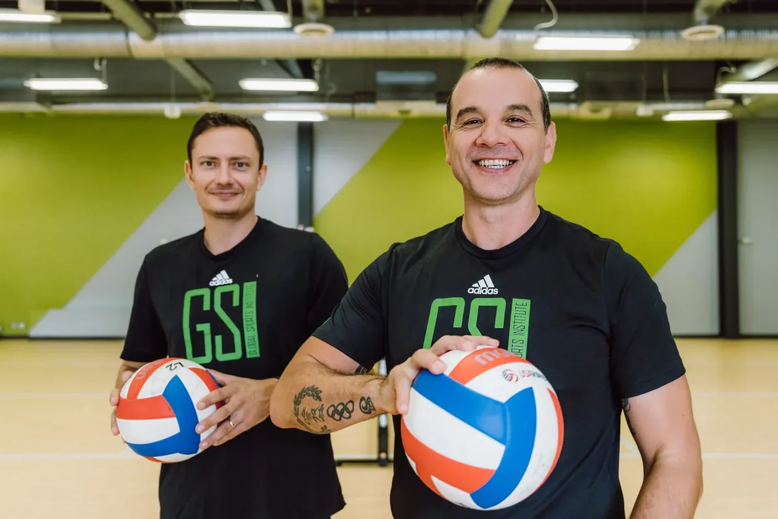 GSI coaches holding volleyballs inside the training facility